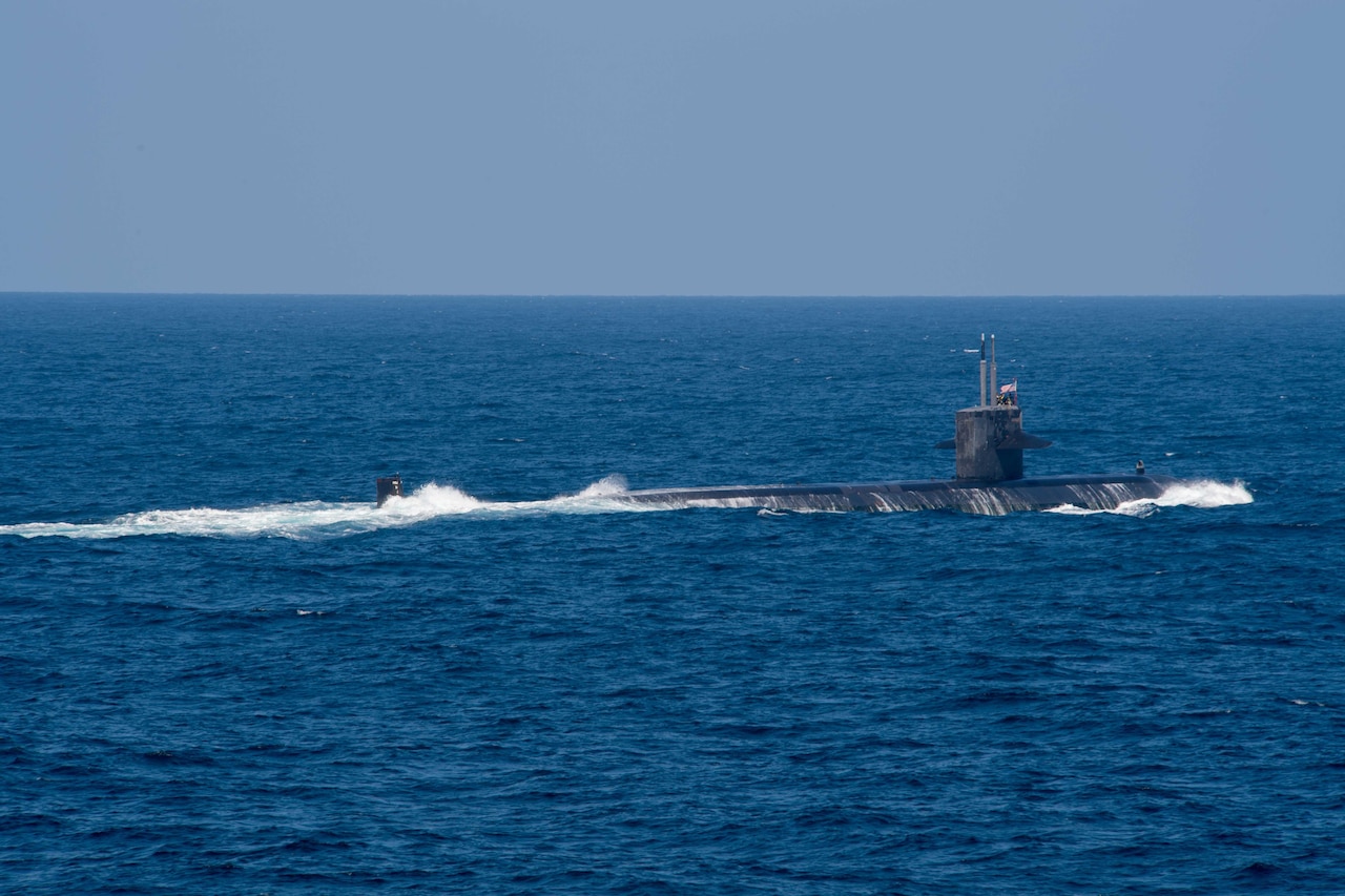 A submarine pushes through the water partially submerged.
