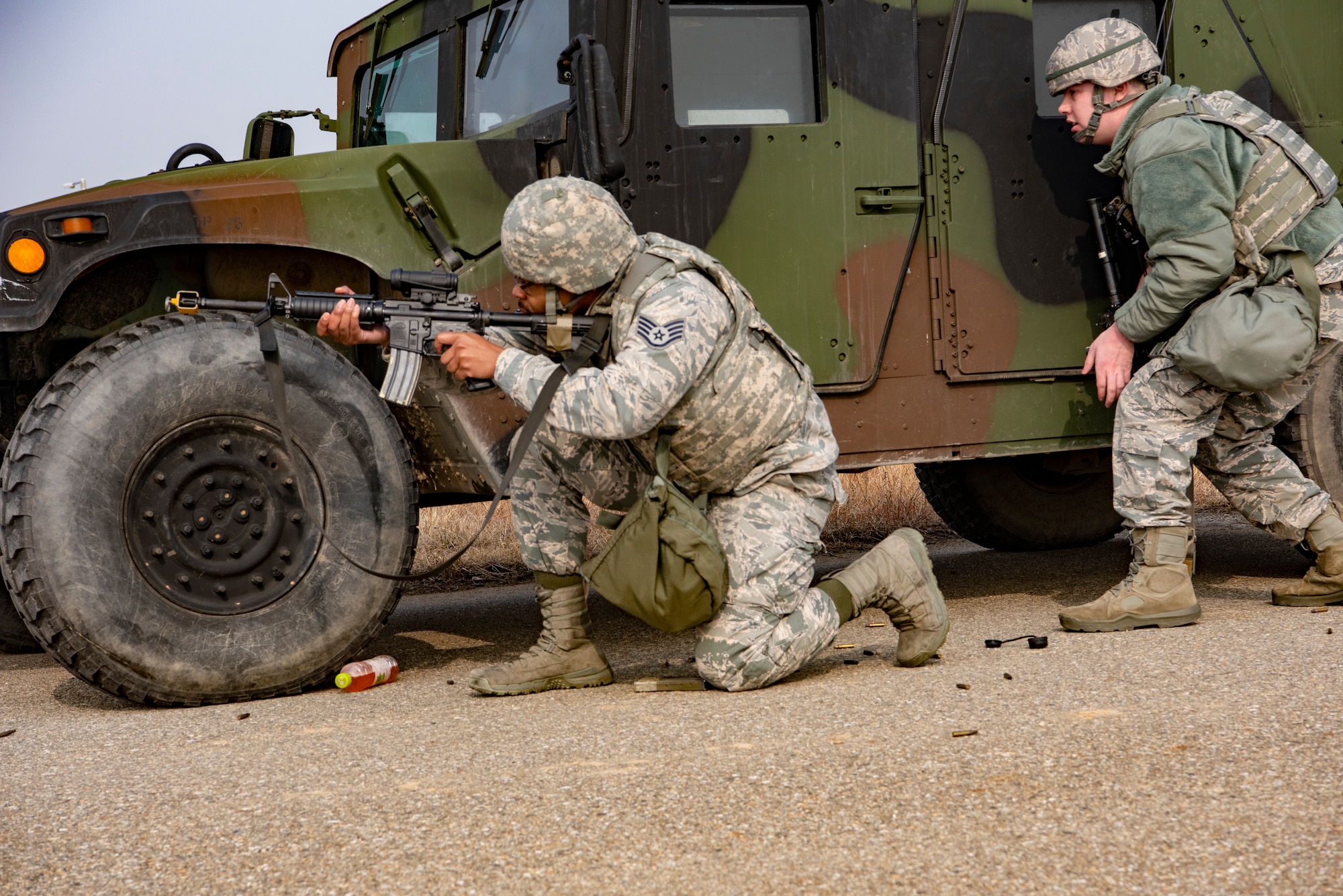 U.S. Air Force Staff Sgt. Chauncey Oliver and Airman 1st Class William Larson, 8th Security Forces Squadron members, use a humvee for cover as they engage simulated hostile forces during routine training at Kunsan Air Base, Republic of Korea, Jan. 14, 2019. The 8th SFS frequently practices combat skills and tactics to ensure rapid response to contingencies. (U.S. Air Force photo by Staff Sgt. Levi Rowse/Released)