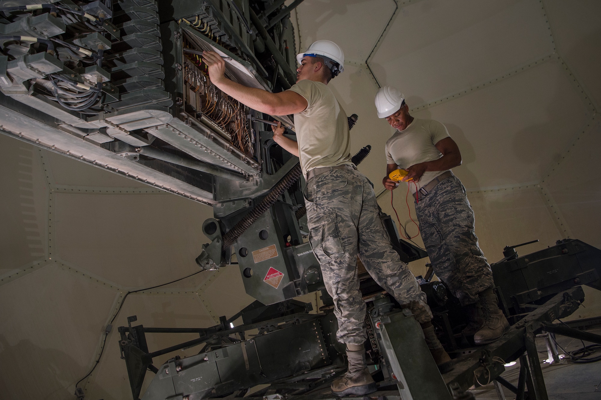 Senior Airman Collin Tully, left, 727th Expeditionary Air Control Squadron, Detachment 3 (EACS DET 3) radar maintainer, and Staff Sgt. Matthew Hawkins, 727th EACS DET 3 radar maintenance NCO in charge, conduct routine maintenance on a transportable radar system (TPS-75) Jan. 14, 2019, at Al Udeid Air Base, Qatar. The 727th EACS consists of a team of 23 Airmen from seven different Air Force Specialty Codes. Together, they ensure TPS-75 radar systems are prepared to identify any aircraft within a 240 nautical mile range of Al Udeid. (U.S. Air Force Tech. Sgt. Christopher Hubenthal)