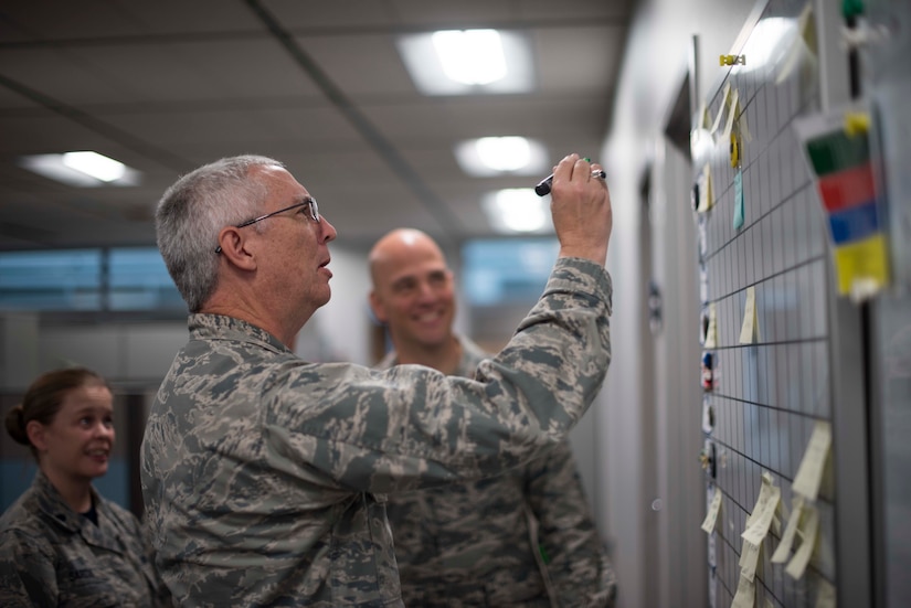Col. Brian Agee, Air Force Space Command Surgeon General Chief of Aerospace Medicine, goes over the daily improvements board, with Lt. Col. Meredith Sarda and Maj. Chris Noah, during the morning meeting at Peterson Air Force Base, Colorado, Oct. 19, 2018. Medical Airmen assigned to U.S. Air Force Space Command are charged with delivering care to the Airmen who launch, monitor and operate the Air Force’s satellite systems. (U.S. Air Force photo by Dave Grim)