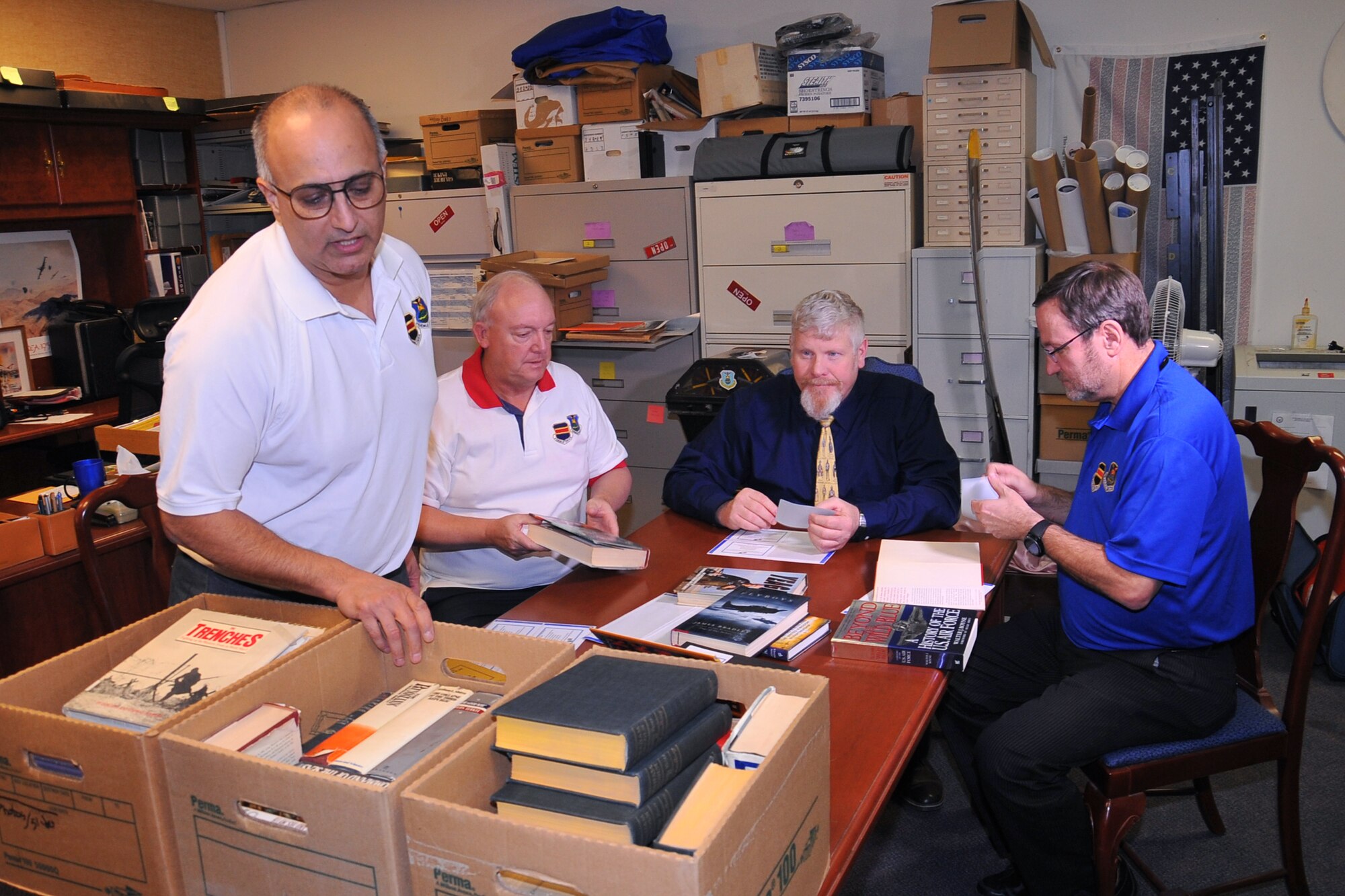 From left to right, Retired U.S. Air Force Col.  Mohan Krishna, Retired U.S. Air Force Col. Joe Spivey, John McQueney, 55th Wing Historian, and Retired Maj.  William Sargent, 55th WG Instructor Navigator, affix donation labels to books contributed by the family of Retired U.S. Air Force Col. John Furniss Watters Sr. Jan. 9, 2019, in the 55th Wing Headquarters, Offutt Air Force Base, Nebraska. Watters passed away last year and the books are part of a collection of more than 100 historical books the family had at their home in Bellevue, Nebraska. (U.S. Air Force Photo by D.P. Heard)