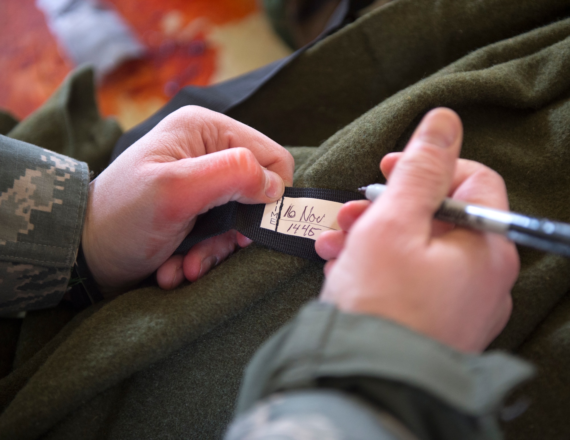 A member from the 133rd Airlift Wing writes the time and date in which the tourniquet was placed onto the simulated patient at the Arden Hills Army Training Site in Arden Hills, Minn., Nov. 16, 2018.