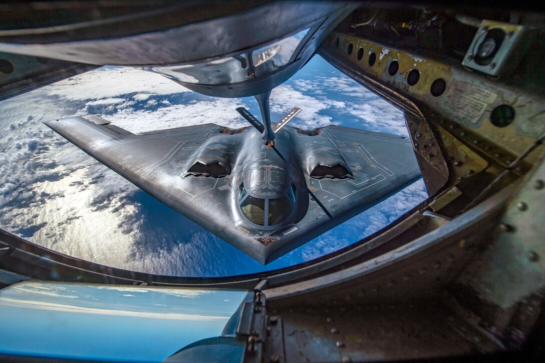 A B-2 bomber gets refueled by another plane mid-air.