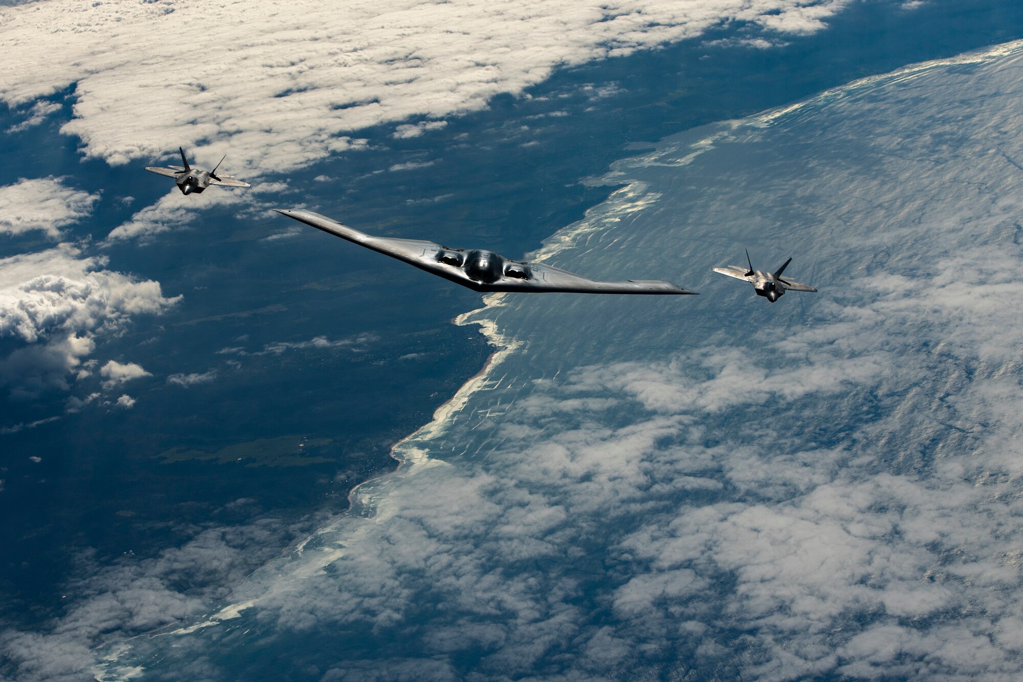 A B-2 Spirit bomber deployed from Whiteman Air Force Base, Missouri, and F-22 Raptors from the Hawaii Air National Guard’s 154th Wing fly near Joint Base Pearl Harbor-Hickam, Hawaii, during an interoperability training mission Jan. 15, 2019.