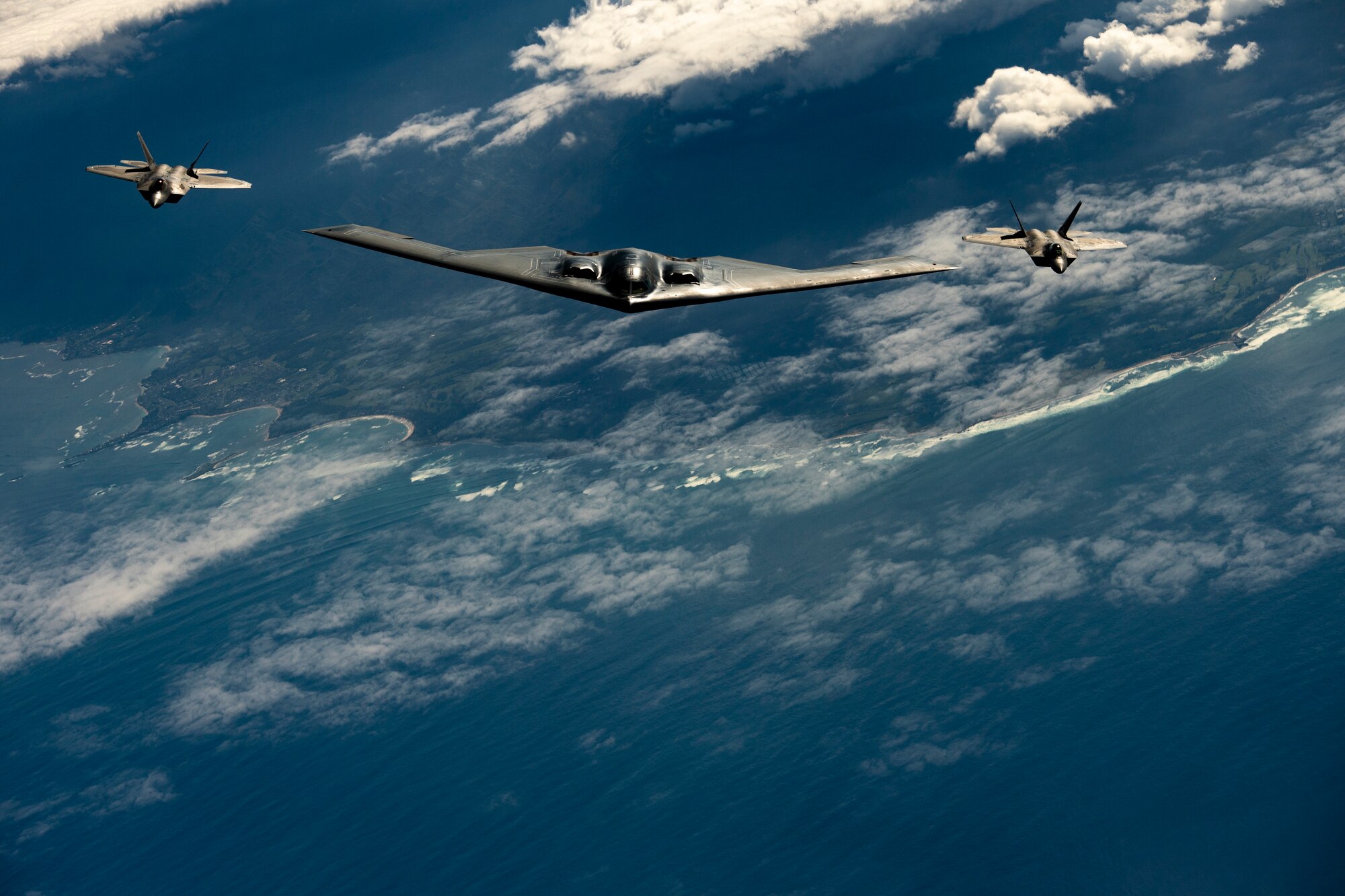 A B-2 Spirit bomber deployed from Whiteman Air Force Base, Missouri, and F-22 Raptors from the Hawaii Air National Guard’s 154th Wing fly near Joint Base Pearl Harbor-Hickam, Hawaii, during a interoperability training mission Jan. 15, 2019.