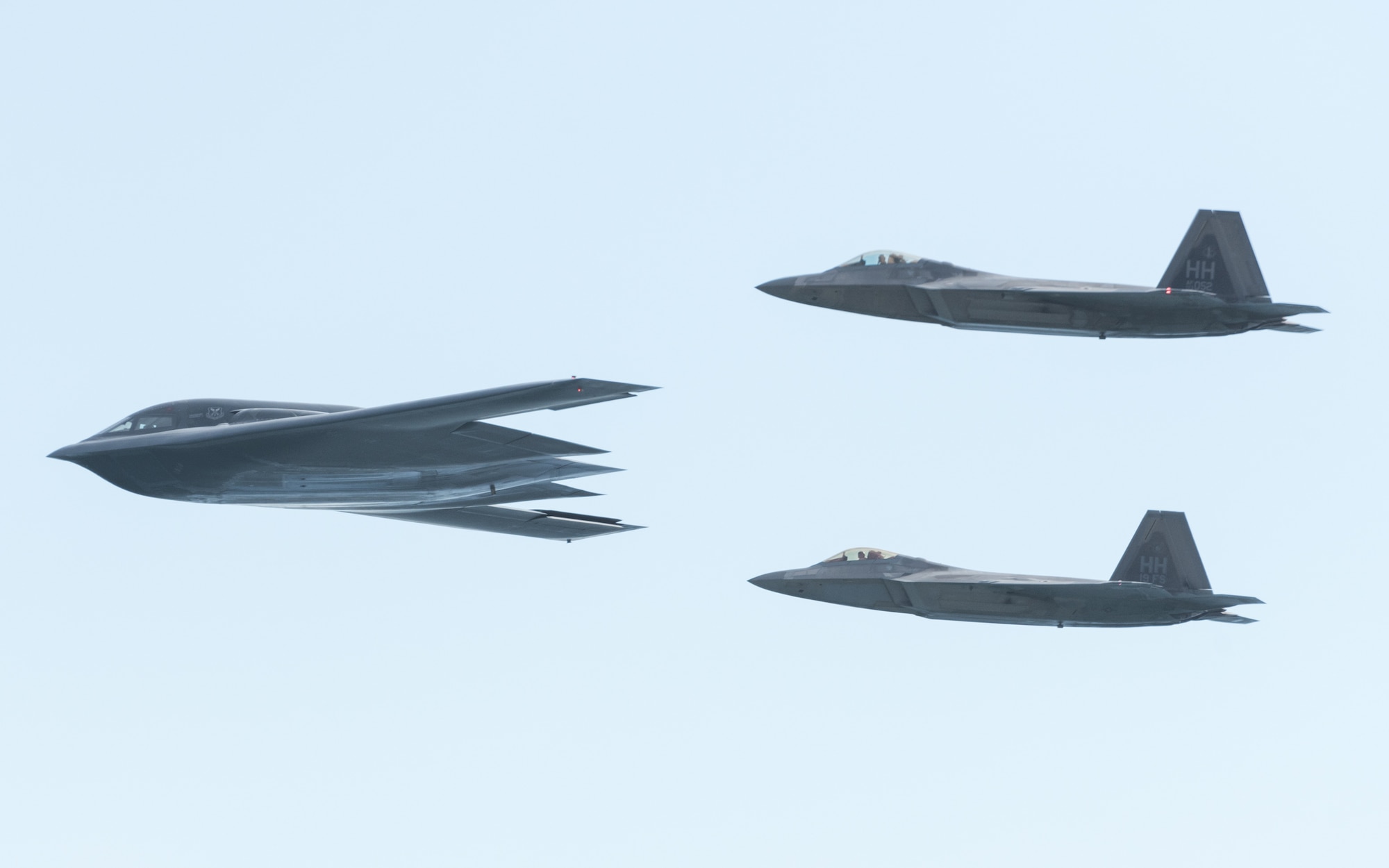 A U.S. Air Force B-2 Spirit bomber deployed from Whiteman Air Force Base, Missouri, and two F-22 Raptors from the 199th Fighter Squadron at Joint Base Pearl Harbor-Hickam, Hawaii, fly in formation near Diamond Head State Monument, Hawaii, during an interoperability training mission Jan. 15, 2019.