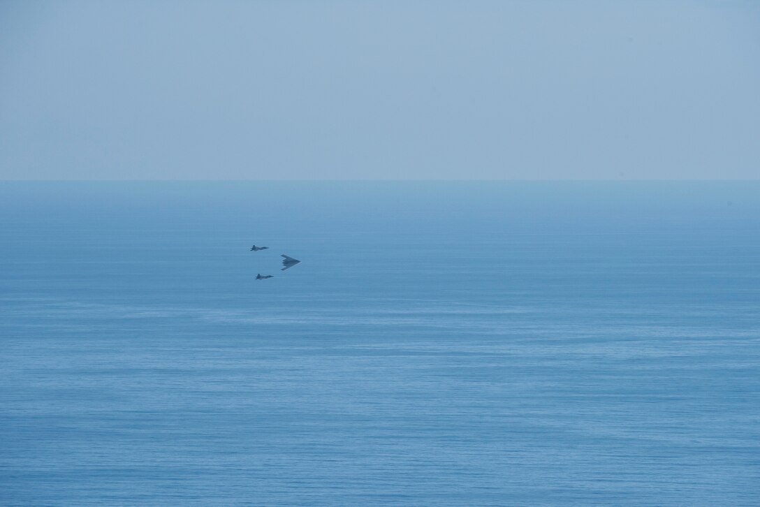 A U.S. Air Force B-2 Spirit bomber deployed from Whiteman Air Force Base, Missouri, and two F-22 Raptors from the 199th Fighter Squadron at Joint Base Pearl Harbor-Hickam, Hawaii, fly in formation near Diamond Head State Monument, Hawaii, after completing interoperability training, Jan. 15, 2019.