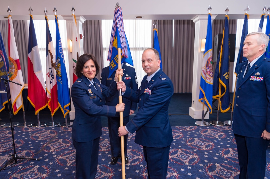 Col. Kathryn Brown, left, 11th Operations Group commander, places the guidon for The United States Air Force Band into the hands of Col. Don Schofield as he takes command of the unit in a ceremony at Joint Base Anacostia-Bolling, Washington D.C., on Jan. 15, 2019.