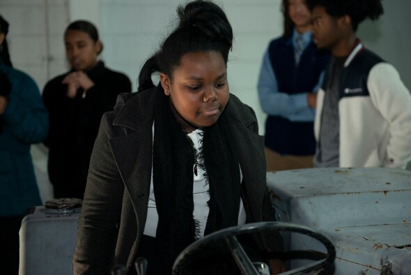A middle school girl sits on a Munitions Jammer 1 loader as part of a school tour at Shaw Air Force Base S.C., Jan. 11, 2019.