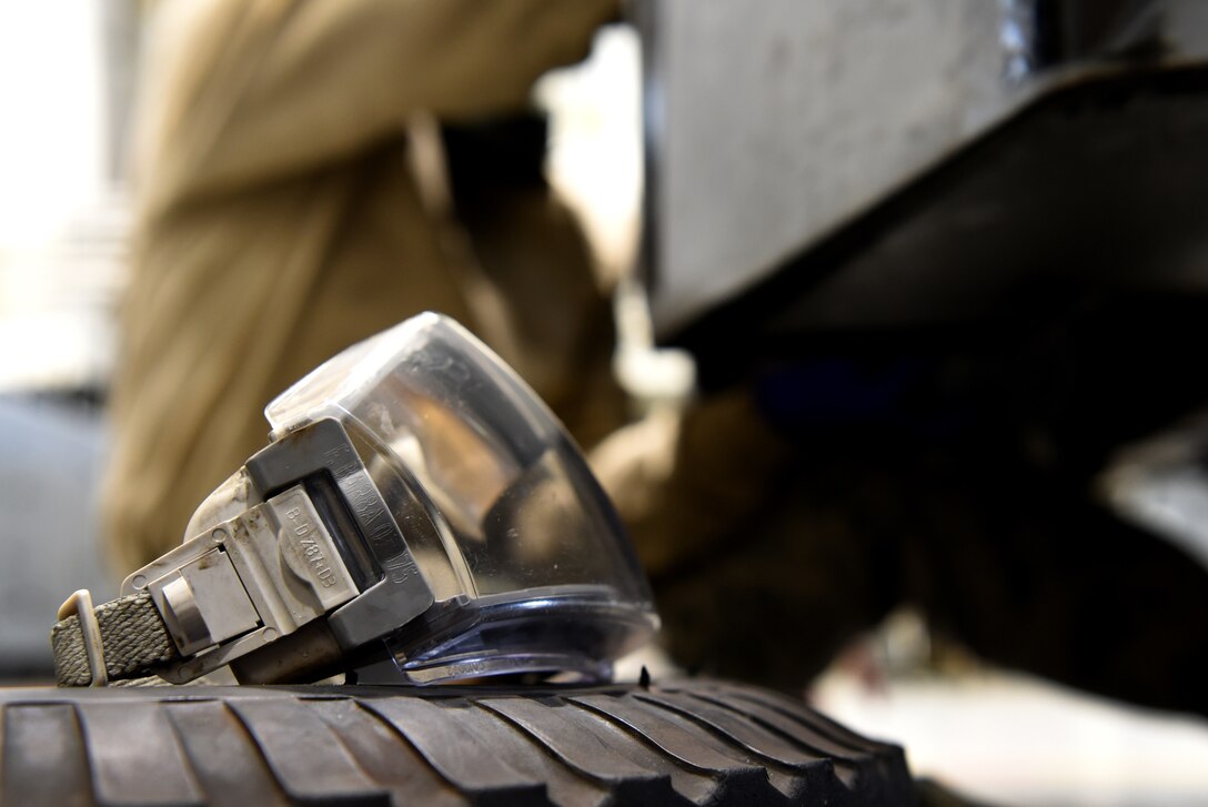 A pair of goggles are ready for use as U.S. Air Force Airman 1st Class Fabiola Barba, 20th Equipment Maintenance Squadron aerospace ground equipment (AGE) technician, makes repairs to a munitions jammer 1-B bomb lift at Shaw Air Force Base, S.C., Jan. 16, 2019.