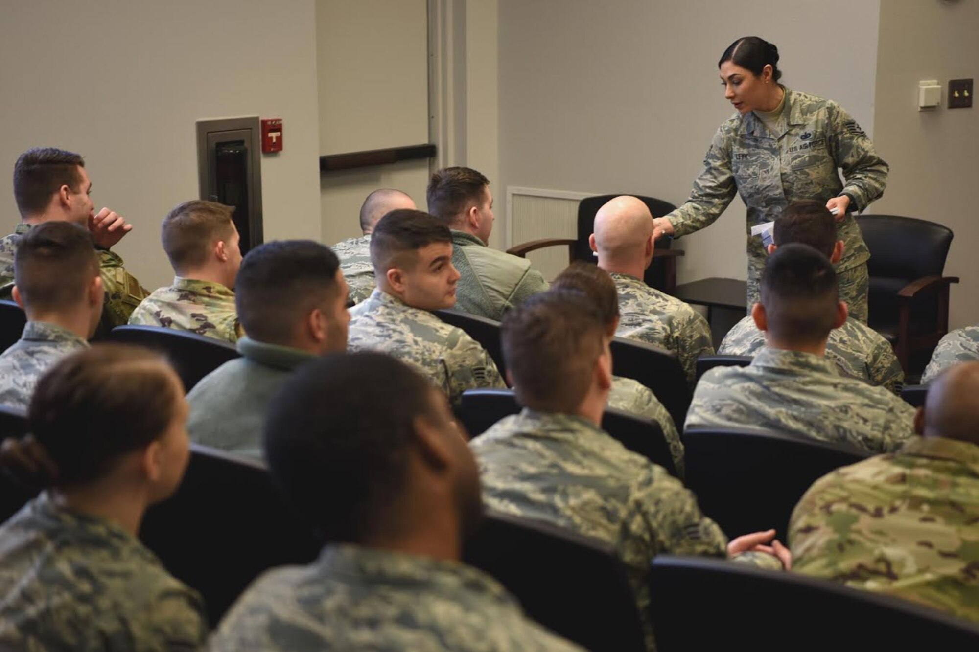 Staff Sgt. Symphony Leyk, 5th Force Support Squadron Airman Leadership School Instructor, hands out envelopes to class leaders, at Minot Air Force Base, N.D., Jan. 15, 2019. Airman leadership school class size may vary, but typically have 64 students broken down into four flights. (U.S. Air Force photo by Airman 1st Class Heather Ley)
