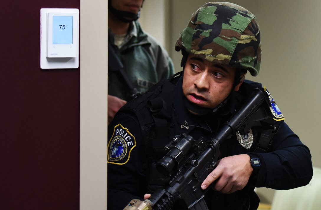 Aaron Watkins, 92nd Security Forces Squadron police officer, peeks around a wall during an active shooter exercise at Fairchild Air Force Base, Washington, Jan. 16, 2019.