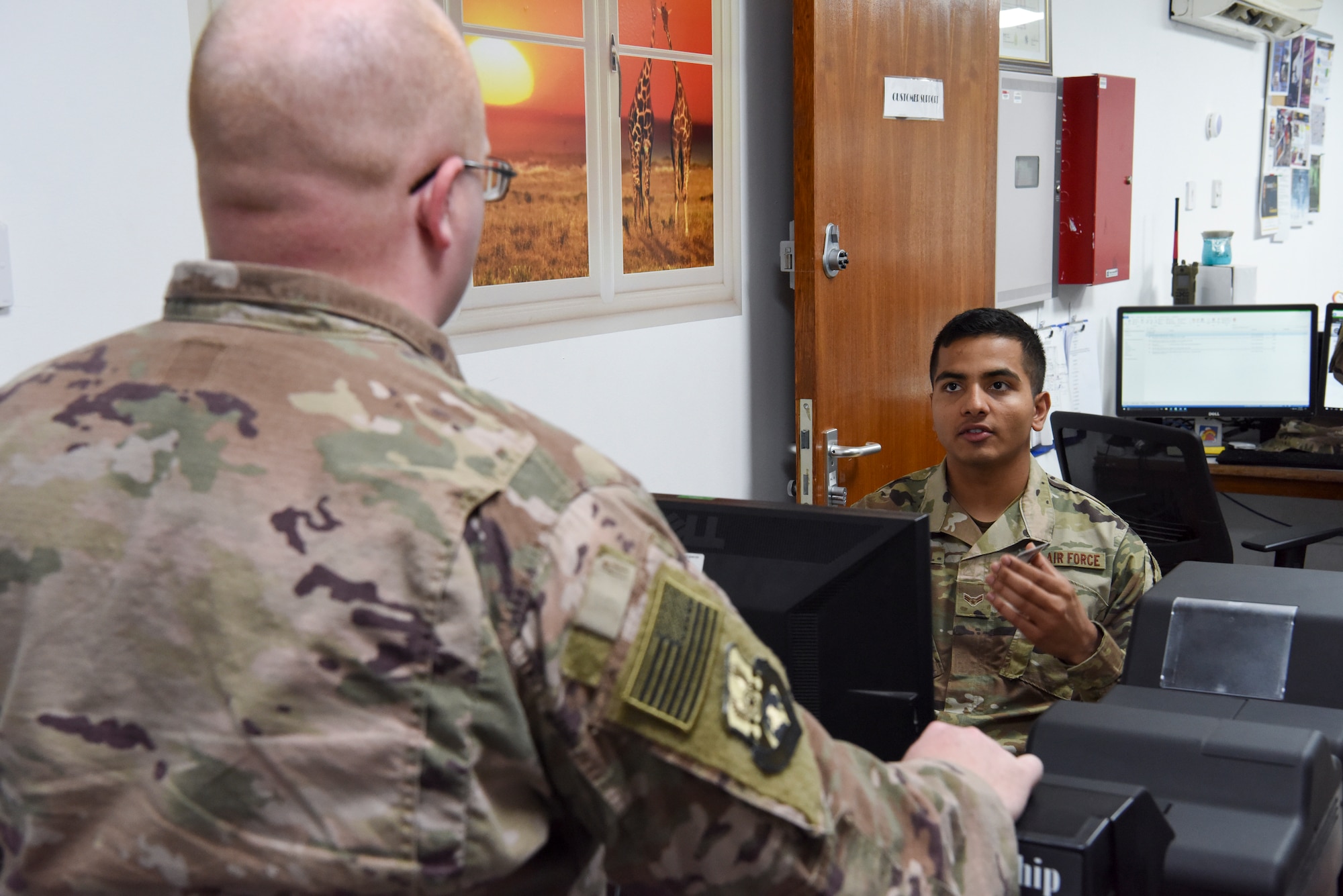 Airman 1st Class Anmol Adhikari, 380th Expeditionary Force Support Squadron PERSCO customer support technician, assists a customer with getting a new identification card Jan. 17, 2019 at Al Dhafra Air Base, United Arab Emirates.