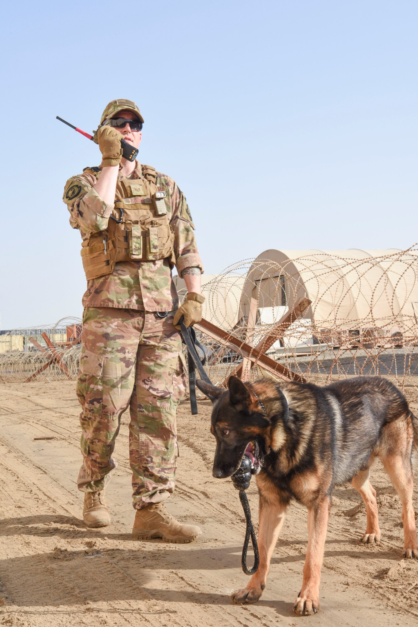 Staff Sgt. David Bafaro, 380th Expeditionary Security Forces Squadron military working dog handler, calls in the results of his search with MWD Simon during a joint training event Jan. 15, 2019 at Al Dhafra Air Base, United Arab Emirates.