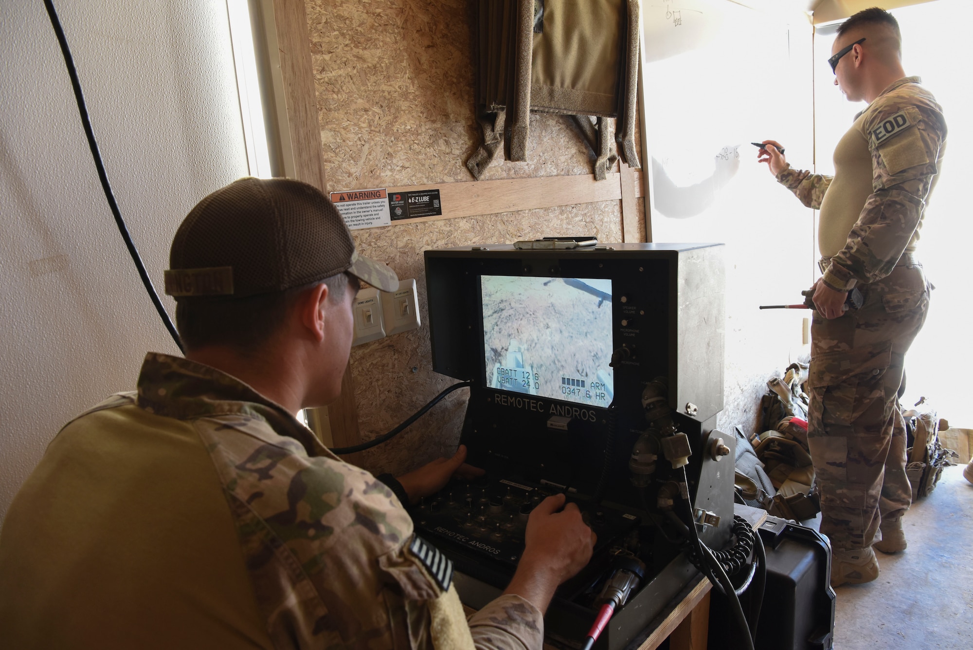 Senior Airman Zach Pennington, 380th Expeditionary Civil Engineer Squadron explosive ordinance disposal team member, operates the robot while Tech. Sgt. Rich Castillo, 380th ECES EOD Team leader conducts a risk assessment during the a joint training event Jan. 15, 2019 at Al Dhafra Air Base, United Arab Emirates.