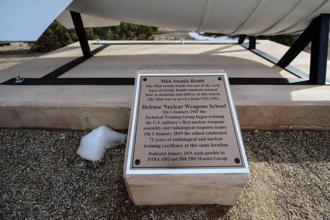 A plaque which reads the dedication of an iconic Mk6 Atomic Bomb sits in front of the Defense Nuclear Weapons School at Kirtland Air Force Base, N.M., Jan. 10, 2019. The school that has been in the same location for the last 72 years is home to providing Nuclear Enterprise and Radiological education and training to those who come through. (U.S. Air Force photo by Staff Sgt. Kimberly Nagle)