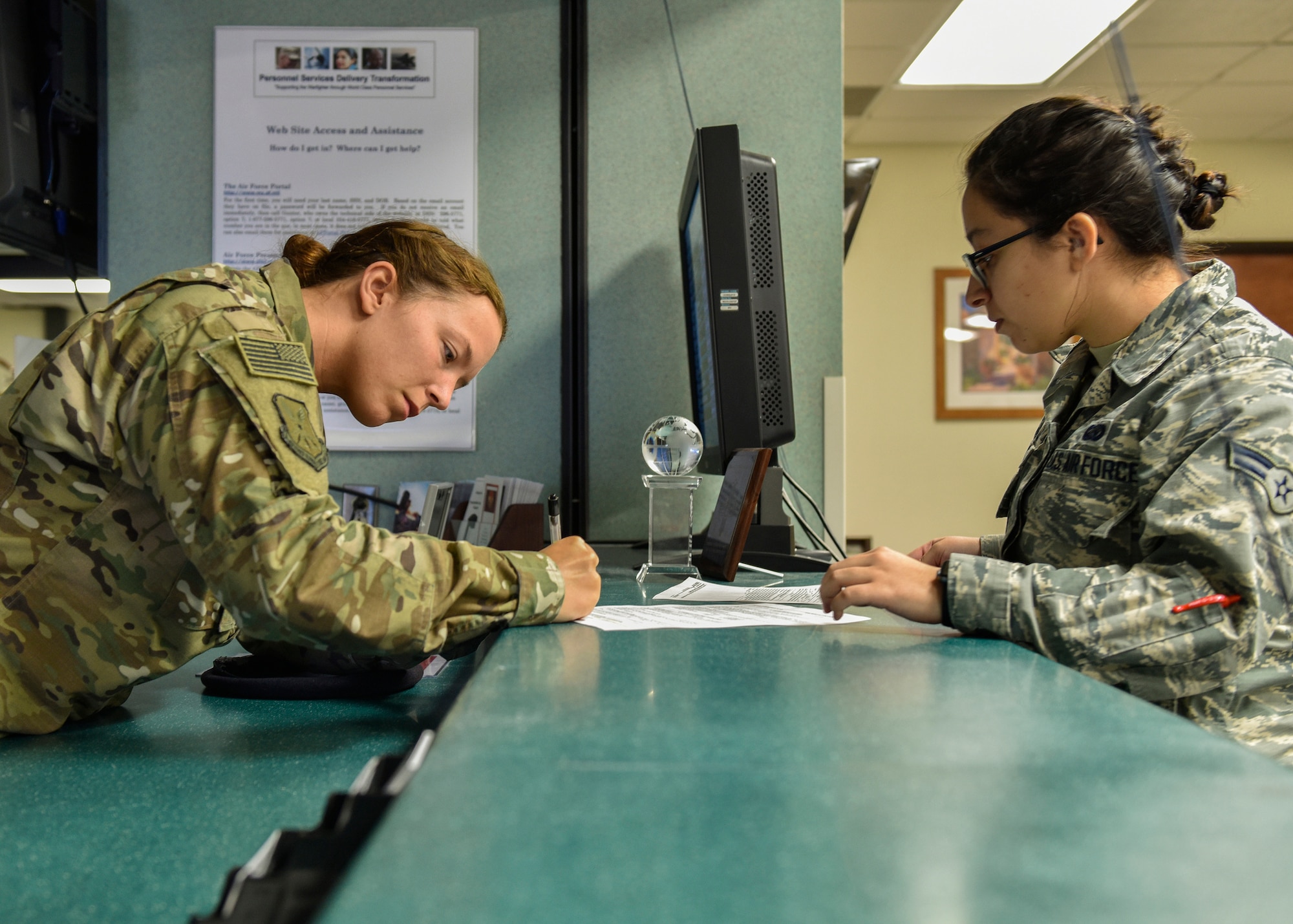 U.S. Air Force Senior Airman Krysta Norman, 377th Weapons System Security Squadron, signs re-enlistment paperwork from Airman 1st Class Jasmine Gonzalez, 377th Force Support Squadron retention technician, at Kirtland Air Force Base, N.M., Jan. 17, 2019. Kirtland’s MPF was awarded the 2018 Air Force Global Strike Command’s MPF of the year. (U.S. Air Force photo by Airman 1st Class Austin J. Prisbrey)