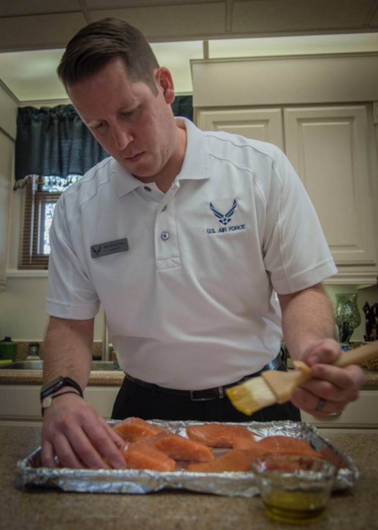 Master Sgt. Brian Hall, enlisted aide to the commander of Air Education and Training Command,   prepares salmon as an entrée for an executive meal Jan. 10, 2019 in the Clark House on Joint Base San Antonio-Randolph, Texas. As he is the AETC major command functional manger, Hall is also in charge of training and management of all AETC enlisted aides.