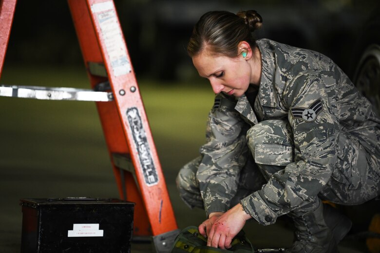 A 493rd weapons load crew member retrieves her tool to assist loading weapons on an F-15C Eagle the 48th Fighter Wing 2018 Load Crew of the Year competition at Royal Air Force Lakenheath, England, Jan. 18, 2019. Load crew competitions help Airmen test their speed and accuracy while focusing on safety and efficiency in a controlled environment. (U.S. Air Force photo by Airman 1st Class Shanice Williams-Jones)