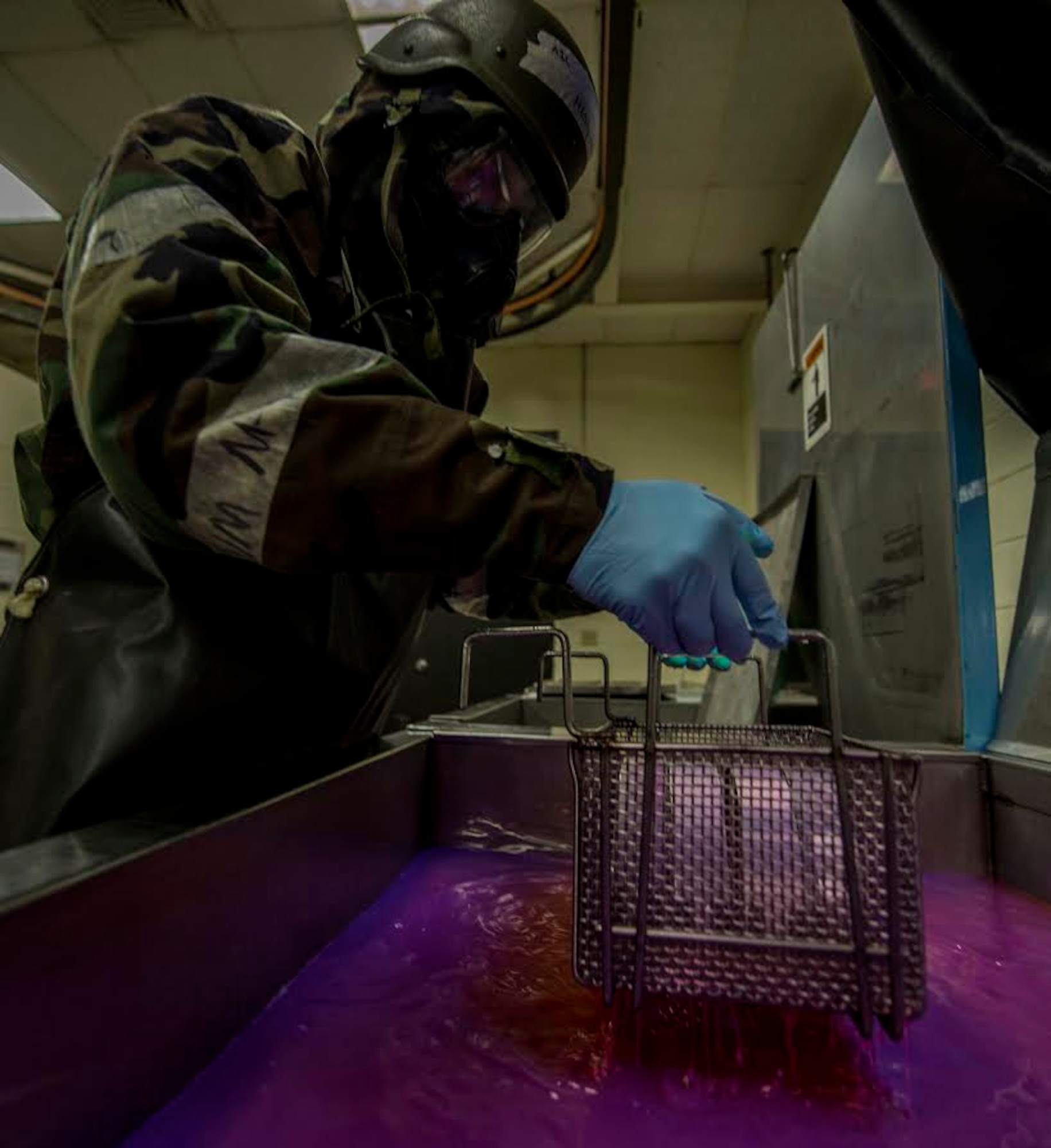 U.S. Air Force Airman 1st Class Ryan Hess, 20th Equipment Maintenance Squadron non-destructive inspection apprentice, dips metal parts into penetrant at Shaw Air Force Base, S.C., Jan. 15, 2019.