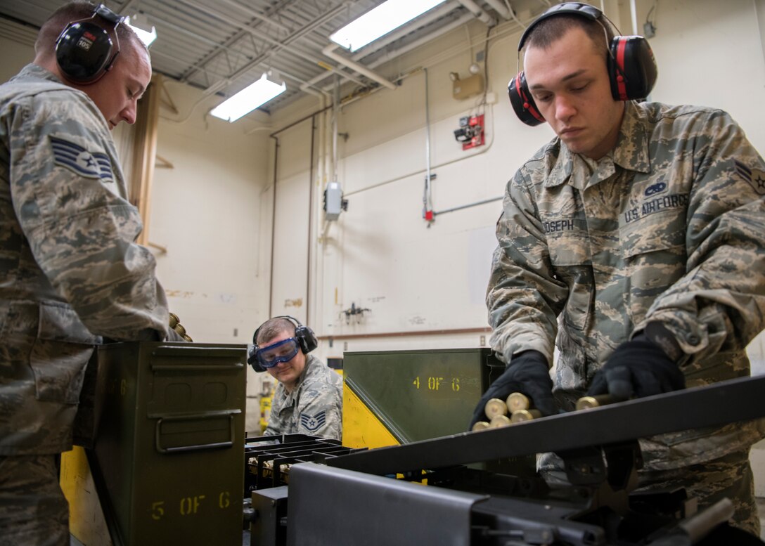 Staff Sergeant Tim Bennett, Staff Sgt. Kyle Bienia, and Airman 1st Class Donoven Joseph, 104th Munitions Flight Airmen, load 20mm ammunition into a Universal Ammunition Loading System Jan. 16, 2018, at Barnes Air National Guard Base, Massachusetts. Bennett and Bienia were mentoring and training Joseph throughout the process. (U.S. Air National Guard photo by Airman 1st Class Randy Burlingame)
