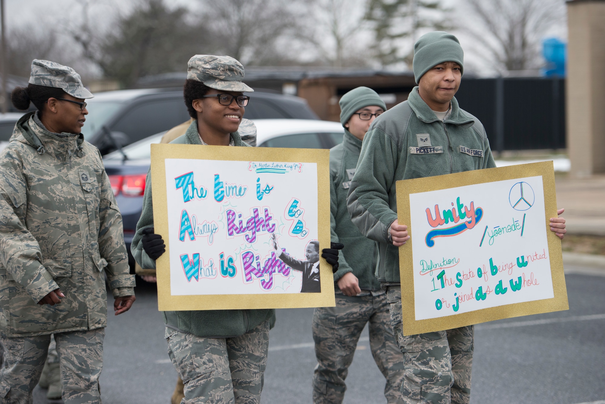 Team Dover Airmen carry signs during the Martin Luther King Jr. Unity Walk Jan. 18, 2019, on Dover Air Force Base, Del. King  was a staunch proponent of the Civil Rights Act and the Voting Rights Act for African Americans in the mid-1960s. (U.S. Air Force photo by Staff Sgt. Jared Duhon)