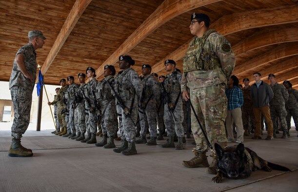 A flight of Airmen stand at parade rest.