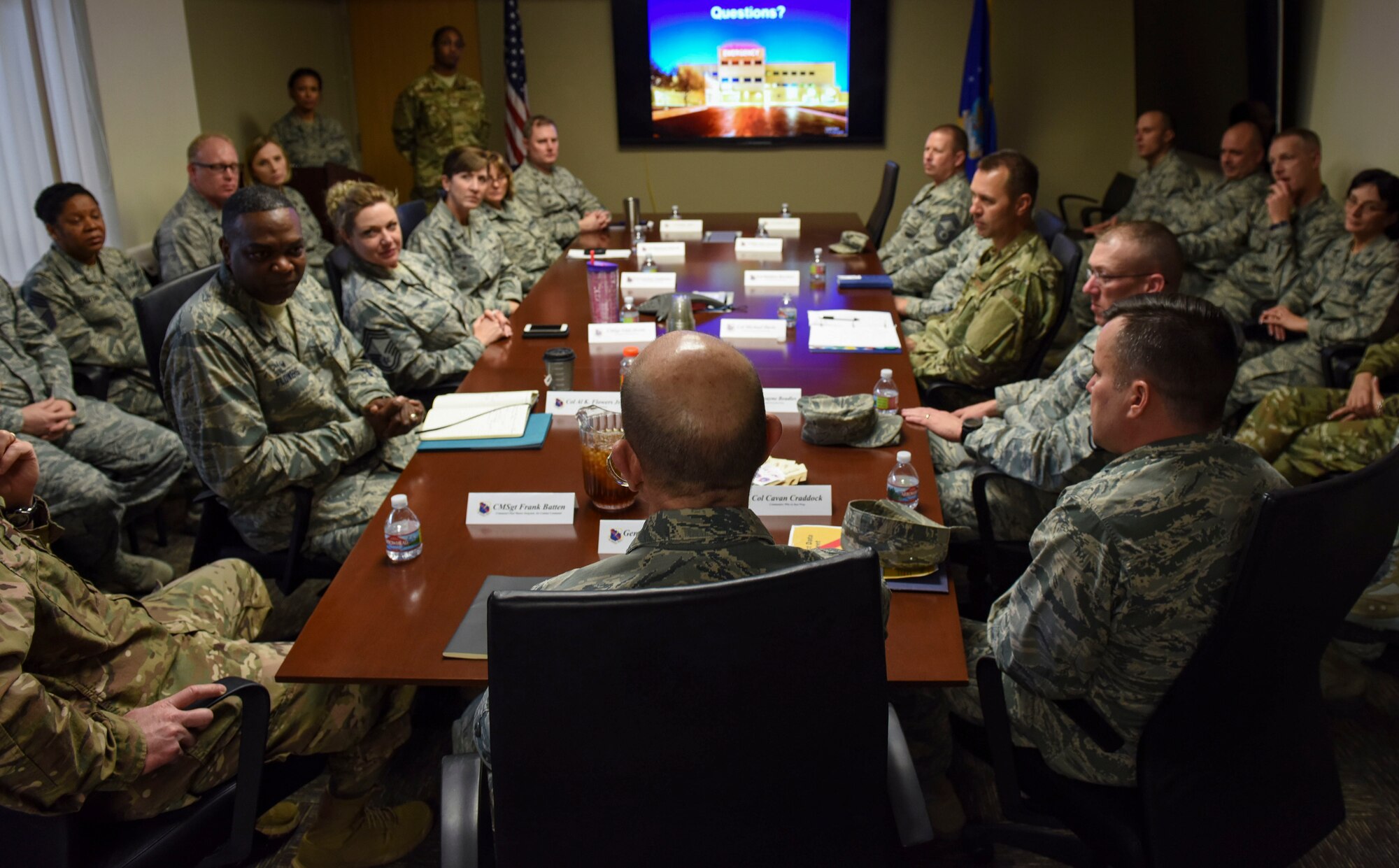 A group of Airmen sit around a table during a conference.