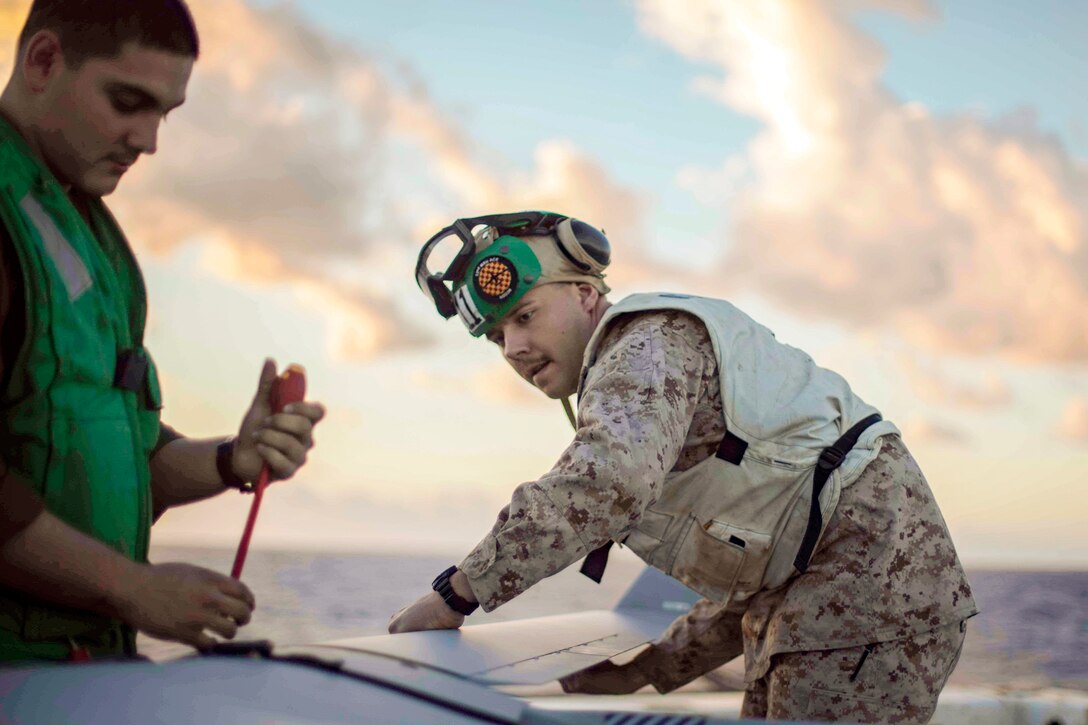 A Marine puts a wing on an unmanned aerial vehicle.