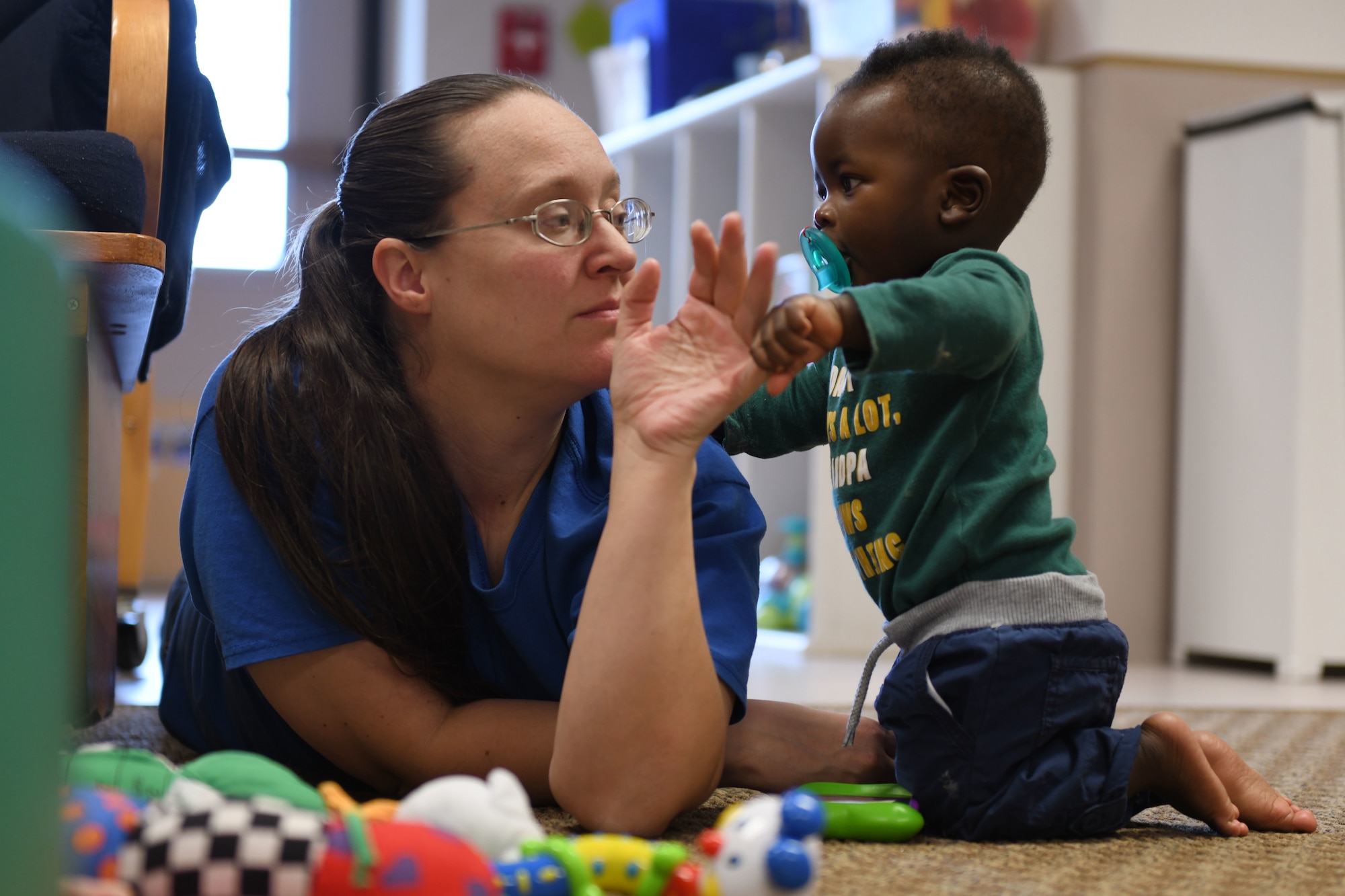 Kristina Arnold, a 28th Force Support Squadron child and youth program assistant, plays with Ryan A. Nyantakyi, the son of Senior Airman Bernice Asiedu, a 28th Bomb Wing financial technician, at the McRaven Child Development Center on Ellsworth Air Force Base, S.D., Dec. 6, 2018. The 28th FSS recently received the results from the November 2018 childcare survey. The results received a total of 208 inputs, and over half of respondents said they use some form of childcare. (U.S. Air Force photo by Airman 1st Class Christina Bennett)