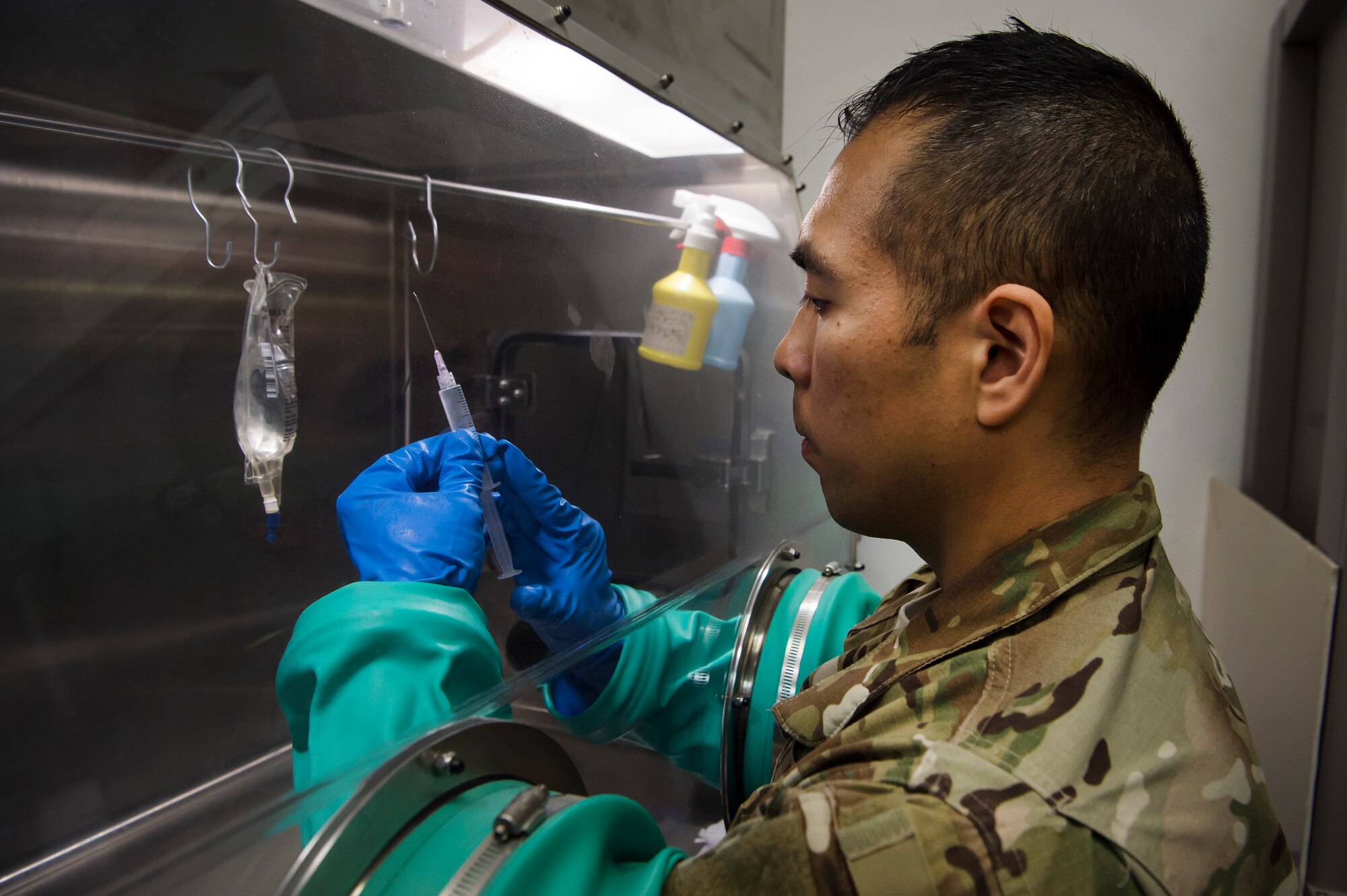 U.S. Air Force Tech. Sgt. Thoney Douangnoy (left), 379th Expeditionary Medical Group pharmacy operations NCO in charge, prepares compounded intravenous medications in the pharmacy at Al Udeid Air Base, Qatar, Jan. 15, 2019. Airmen prepare compounded IV medications for inpatient and air-evacuated patients, with the practice performed in an IV hood to ensure product sterility. (U.S. Air Force photo by Tech. Sgt. Christopher Hubenthal)