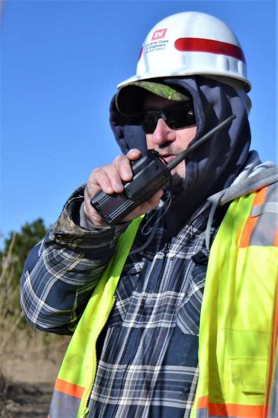 Man in safety vest and hard had talks on walkie-talkie