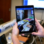 A demonstrator shows how augmented reality can be used to view floating dialogue boxes for individual parts of a mock missile during a demonstration Jan. 8, 2019, at Joint Base Langley-Eustis, Virginia. Augmented reality is one way Airmen could use advanced technology to enhance their training in the field.