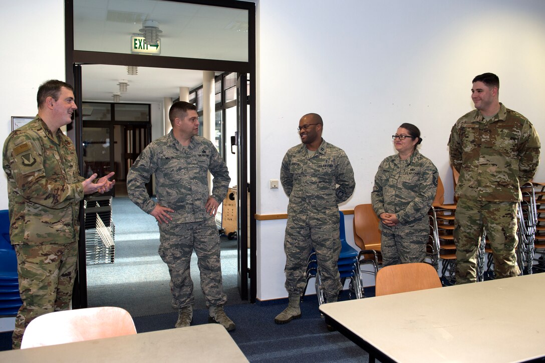 U.S. Air Force Brig. Gen. Mark R. August, 86th Airlift Wing commander (left), recognizes the Ramstein Airlifters of the Week on Ramstein Air Base, Germany, Jan. 17, 2019. U.S. Air Force Capt. Alex Johnson, 86th AW chaplain, U.S. Air Force Master Sgt. Norma Johnson, 86th AW readiness and training flight chief, and U.S. Air Force Staff Sgt. Jacob Johnson, 86th AW non-commissioned officer in charge of education and training, received commander’s coins for their actions in supporting more than 54,000 Team Ramstein members’ spiritual resiliency. (U.S. Air Force photo by Staff Sgt. Jonathan Bass)
