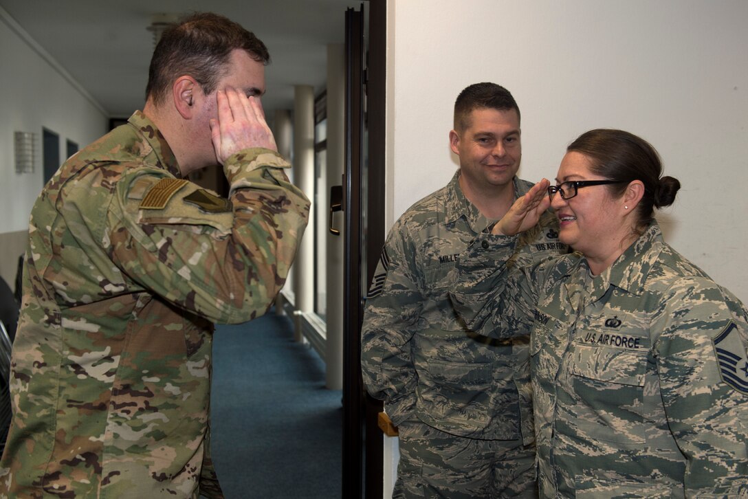 U.S. Air Force Master Sgt. Norma Johnson, 86th Airlift Wing readiness and training flight chief (right), salutes U.S. Air Force Brig. Gen. Mark R. August, 86th AW commander, after being coined by August on Ramstein Air Base, Germany, Jan. 17, 2019. Johnson supports base religious programs, spiritual care, crisis intervention counseling and advices leadership on religious matters affecting Airmen. (U.S. Air Force photo by Staff Sgt. Jonathan Bass)