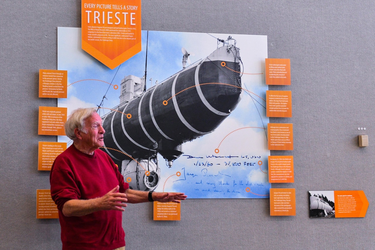 A man stands beside a museum exhibit.