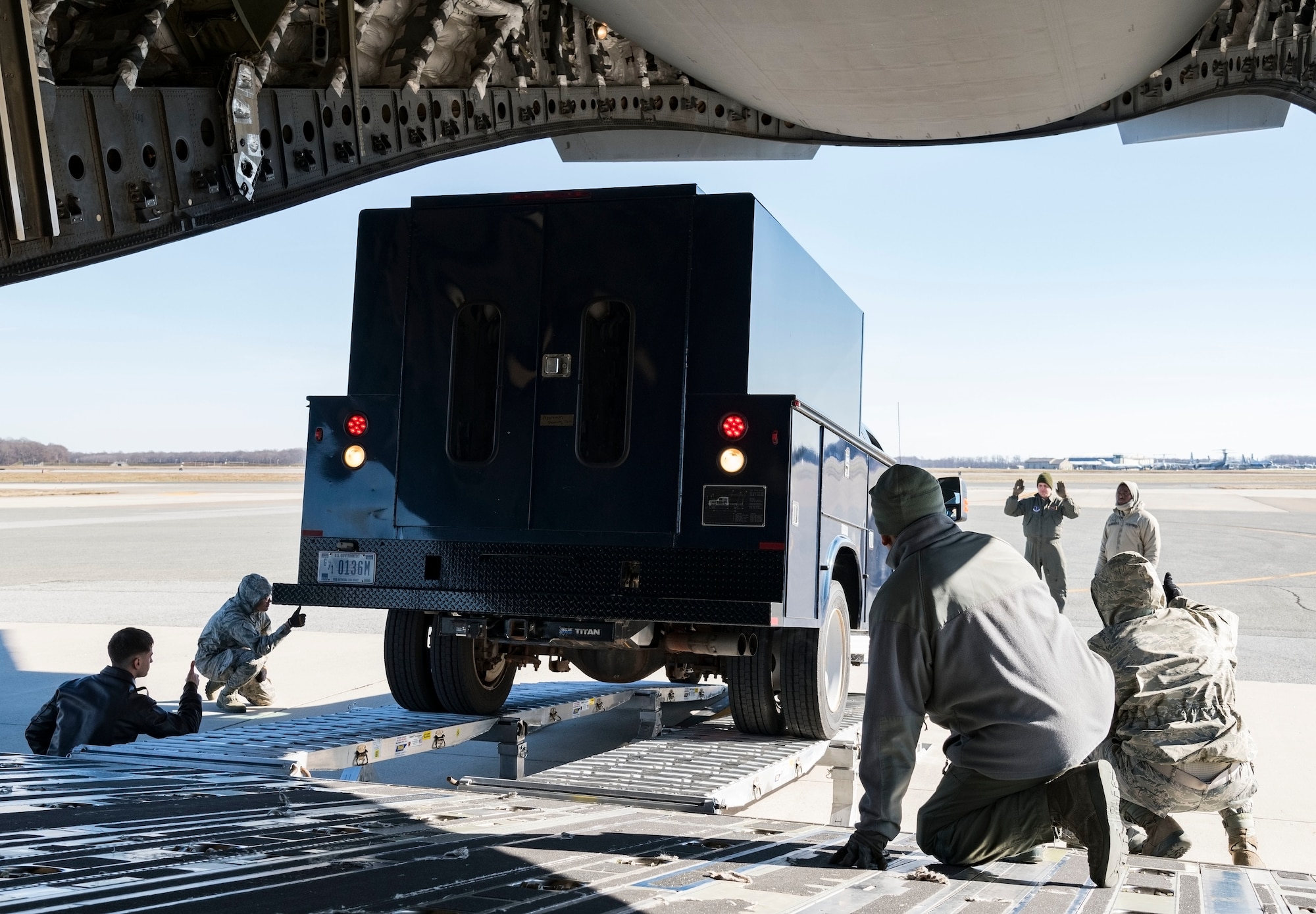 Ramp operations personnel assigned to the 436th Aerial Port Squadron along with 137th Airlift Squadron loadmasters from Stewart Air National Guard Base, Newburgh, N.Y., watch a vehicle back up onto a C-17 Globemaster III using the DOMOPS Airlift Modular Approach Shoring Jan. 11, 2019, at Dover Air Force Base, Del. The modular shoring was used to upload five vehicles belonging to the Delaware National Guard's 31st Civil Support Team, Weapons of Mass Destruction headquartered in Smyrna, Del. (U.S. Air Force photo by Roland Balik)