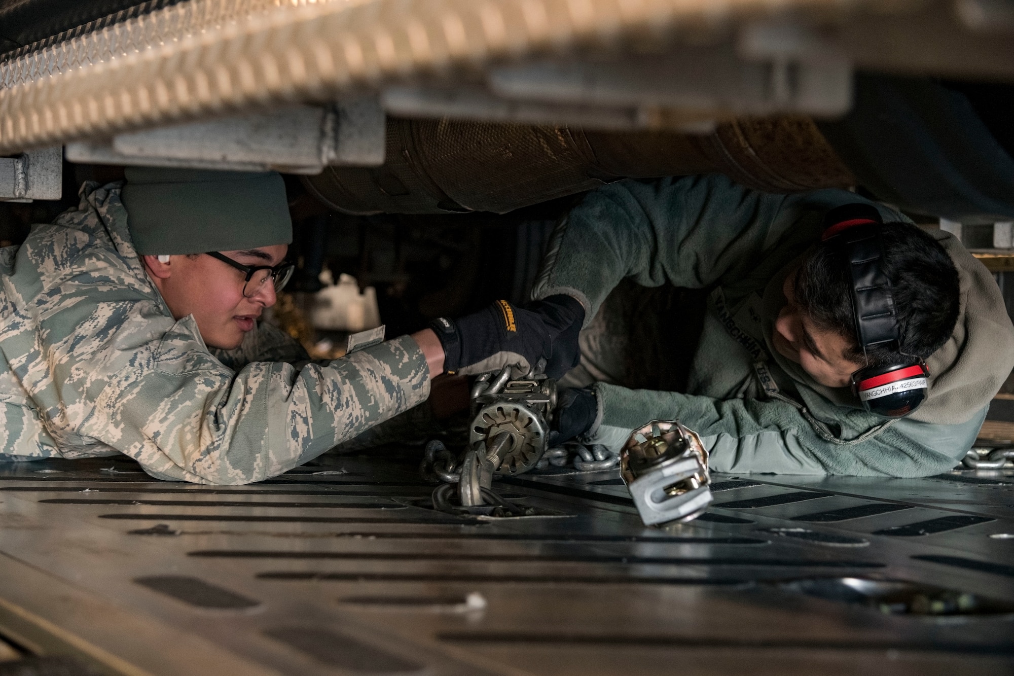 Ramp operations specialists, Airman 1st Class Francisco Garcia Matos, 71st Aerial Port Squadron, Joint Base Langley-Eustis, Va., and Jacob Vangchhia, 436th APS, install cargo chains to secure a vehicle to a C-17 Globemaster III cargo floor Jan. 11, 2019, at Dover Air Force Base, Del. Garcia Matos and Vangchhia, along with other ramp operations personnel loaded five vehicles belonging to the Delaware National Guard's 31st Civil Support Team, Weapons of Mass Destruction headquartered in Smyrna, Del. The 71st APS is a geographically-separated unit of the 512th Airlift Wing, Dover AFB (U.S. Air Force photo by Roland Balik)