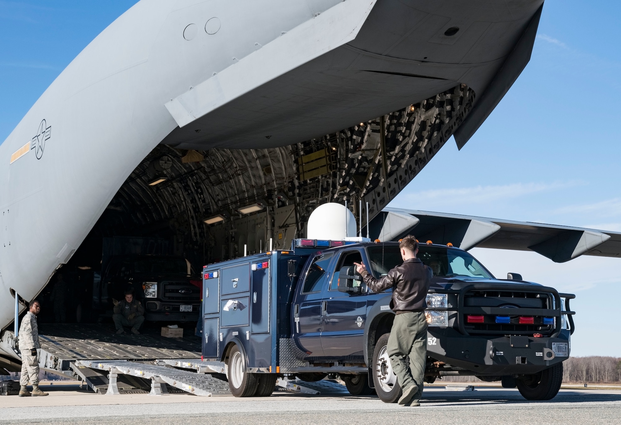Staff Sgt. Ryan Stanich, 137th Airlift Squadron C-17 loadmaster, Stewart Air National Guard Base, Newburgh, N.Y., marshals a vehicle backing up on the DOMOPS Airlift Modular Approach Shoring Jan. 11, 2019, at Dover Air Force Base, Del. The vehicles belong to the Delaware National Guard's 31st Civil Support Team, Weapons of Mass Destruction headquartered in Smyrna, Del. The vehicles and team members were airlifted to Florida to support the Florida National Guard during a large-scale training exercise Jan. 14-18. The 31st CST maintains the capability to mitigate the consequences of any WMD or Nuclear, Biological, and Chemical event, whether natural or man-made. They are experts in WMD effects and NBC defense operations. (U.S. Air Force photo by Roland Balik)