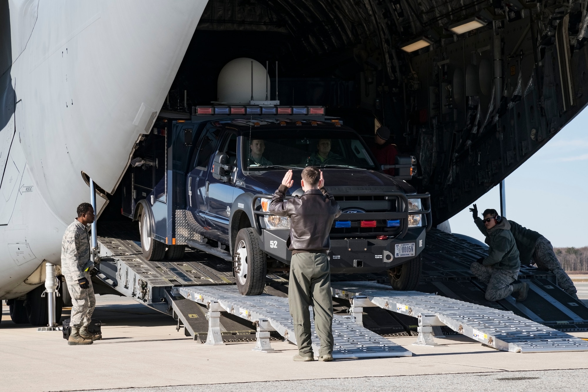 With the assistance of 436th Aerial Port Squadron ramp operations personnel, Staff Sgt. Ryan Stanich, 137th Airlift Squadron C-17 loadmaster, Stewart Air National Guard Base, Newburgh, N.Y., marshals a vehicle backing up on the DOMOPS Airlift Modular Approach Shoring Jan. 11, 2019, at Dover Air Force Base, Del. The vehicles belong to the Delaware National Guard's 31st Civil Support Team, Weapons of Mass Destruction headquartered in Smyrna, Del. The vehicles and team members were airlifted to Florida to support the Florida National Guard during a large-scale training exercise Jan. 14-18. The 31st CST maintains the capability to mitigate the consequences of any WMD or Nuclear, Biological, and Chemical event, whether natural or man-made. They are experts in WMD effects and NBC defense operations. (U.S. Air Force photo by Roland Balik)