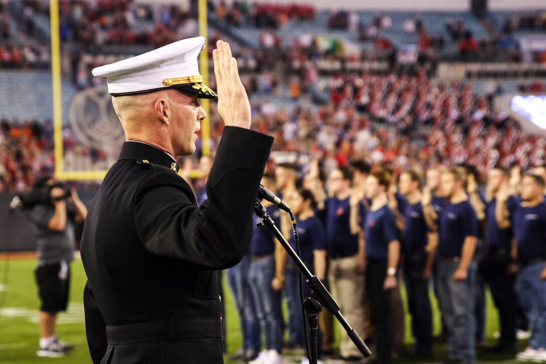 Brig. Gen. James F. Glynn, commanding general of Marine Corps Recruit Depot Parris Island and the Eastern Recruiting Region, swears young men and women into the Marine Corps during the pre-game show of TaxSlayer Gator Bowl, Dec. 31, 2018, at TIAA Bank Field in Jacksonville, Florida. Glynn was invited by the Jacksonville Sports Council to be the guest-of-honor during the game. (U.S. Marine Corps Photo by Cpl. Mike Hernandez)