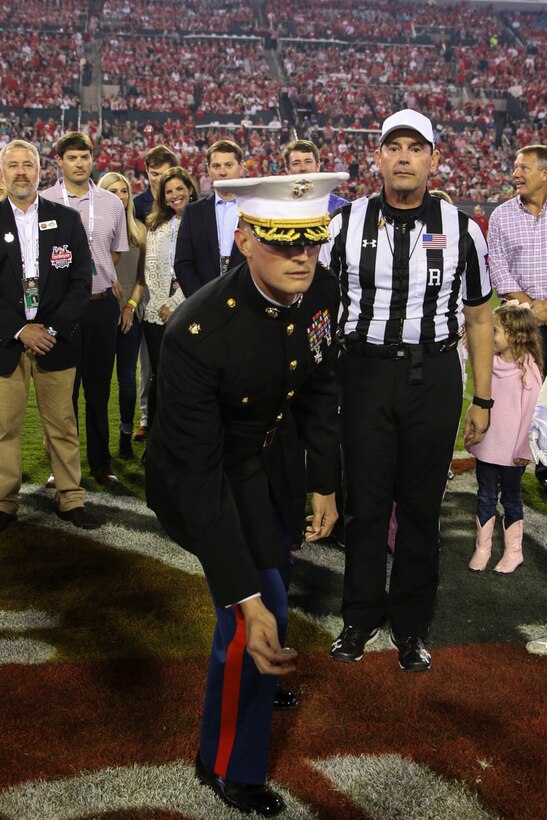 Maj. Joseph Gill, commanding officer of Recruiting Station Jacksonville, tosses the coin on TIAA Bank Field before the start of TaxSlayer Gator Bowl, Dec. 31, 2018, in Jacksonville, Florida. Gill was invited by the Jacksonville Sports Council to execute the coin-toss before the game. (U.S. Marine Corps Photo by Cpl. Mike Hernandez)