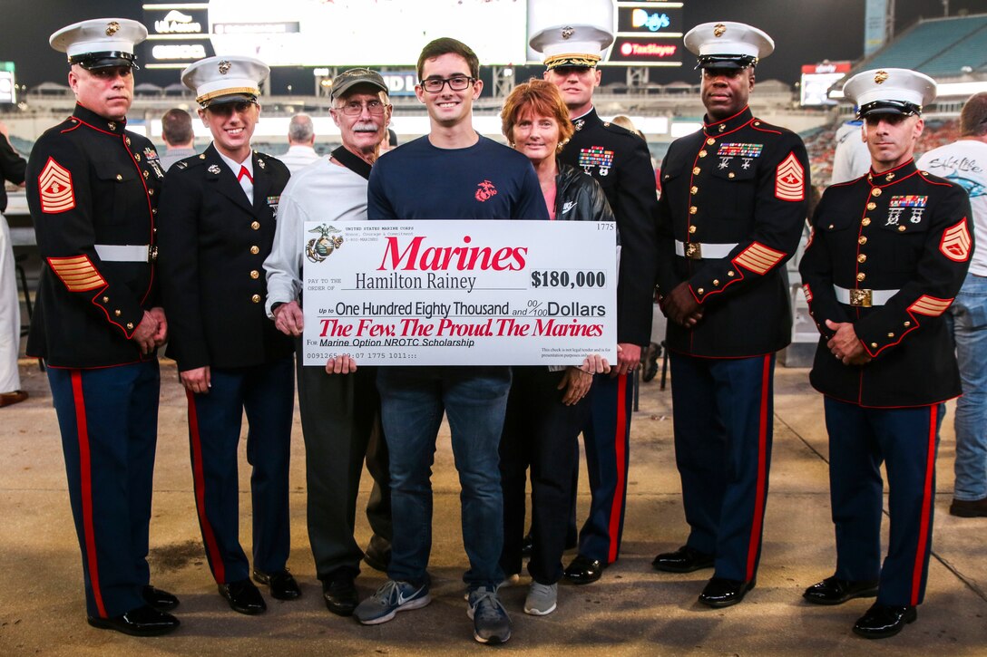 Hamilton Rainey, a poolee with Recruiting Substation Yulee, Recruiting Station Jacksonville, is presented a Navy Reserves Officer Training Corps Scholarship at TaxSlayer Gator Bowl, Dec. 31, 2018, at TIAA Bank Field in Jacksonville, Florida. Rainey was selected among four other applicants in RS Jacksonville’s area of operation. (U.S. Marine Corps Photo by Cpl. Mike Hernandez)