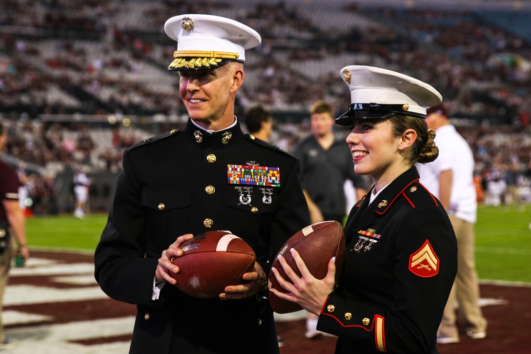 Brig. Gen. James F. Glynn, commanding general of Marine Corps Recruit Depot Parris Island and the Eastern Recruiting Region, holds one of the game footballs beside Cpl. Eliyanna Heilig, a canvassing recruiter with Recruiting Substation Ponte Vedra, Recruiting Station Jacksonville, at TaxSlayer Gator Bowl, Dec. 31, 2018, at TIAA Bank Field in Jacksonville, Florida. Glynn was invited by the Jacksonville Sports Council to be the guest-of-honor during the game. (U.S. Marine Corps Photo by Cpl. Mike Hernandez)