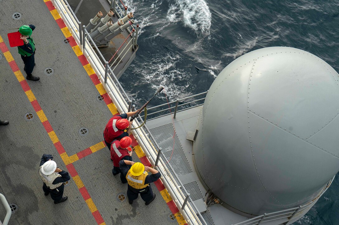 Sailors prepare to fire a shot line.