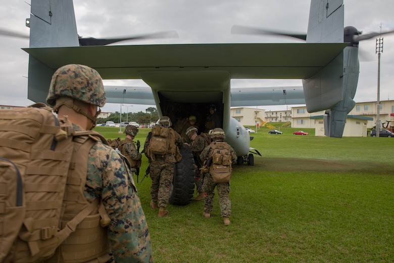 Landing support specialists roll a Medium Tactical Vehicle Replacement tire onto an MV-22B Osprey during helicopter support team training at Camp Foster, Okinawa, Japan, Jan. 14, 2019. Landing Support Company, 3rd Transportation Support Battalion, Combat Logistics Regiment 3, 3rd Marine Logistics Group supported Marine Medium Tiltrotor Squadron 265, Marine Aircraft Group 36, 1st Marine Aircraft Wing during external lift training, which ensures pilots and landing support specialists are able to communicate as well as transport gear from one location to another. (U.S. Marine Corps Photo by Cpl. André T. Peterson Jr.)