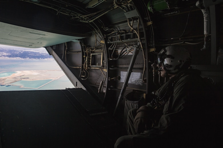 A crew chief looks out of the back of an MV-22B Osprey during helicopter support team training at Camp Foster, Okinawa, Japan, Jan. 14, 2019. Landing Support Company, 3rd Transportation Support Battalion, Combat Logistics Regiment 3, 3rd Marine Logistics Group supported Marine Medium Tiltrotor Squadron 265, Marine Aircraft Group 36, 1st Marine Aircraft Wing during external lift training, which ensures pilots and landing support specialists are able to communicate and transport gear from one location to another. (U.S. Marine Corps Photo by Cpl. André T. Peterson Jr.)