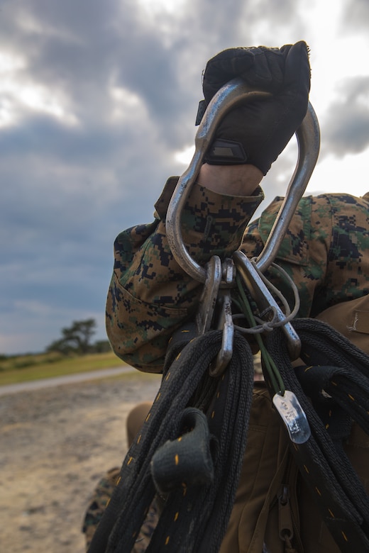 An apex ring connects a cargo net to an MV-22B Osprey's cargo hook during helicopter support team training at Camp Hansen, Okinawa, Japan, Jan. 14, 2019. Landing Support Company, 3rd Transportation Support Battalion, Combat Logistics Regiment 3, 3rd Marine Logistics Group supported Marine Medium Tiltrotor Squadron 265, Marine Aircraft Group 36, 1st Marine Aircraft Wing during external lift training, which provides valuable flight training hours for pilots as well as field training for Landing Support Company. (U.S. Marine Corps Photo by Cpl. André T. Peterson Jr.)