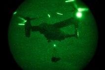 An MV-22B Osprey lifts cargo during night operations with assistance from a helicopter support team at Camp Hansen, Okinawa, Japan, Jan. 14, 2019. Landing Support Company, 3rd Transportation Support Battalion, Combat Logistics Regiment 3, 3rd Marine Logistics Group supported Marine Medium Tiltrotor Squadron 265, Marine Aircraft Group 36, 1st Marine Aircraft Wing during external lift training, which ensures pilots and landing support specialists are able to communicate as well as transport gear from one location to another. (U.S. Marine Corps Photo by Cpl. André T. Peterson Jr.)