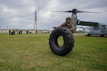 Lance Cpl. David S. Gutierrez rolls a Medium Tactical Vehicle Replacement tire during helicopter support team training at Camp Foster, Okinawa, Japan, Jan. 14, 2019. Landing Support Company, 3rd Transportation Support Battalion, Combat Logistics Regiment 3, 3rd Marine Logistics Group supported Marine Medium Tiltrotor Squadron 265, Marine Aircraft Group 36, 1st Marine Aircraft Wing during external lift training, which ensures pilots and landing support specialists are able to communicate and transport gear from one location to another. Gutierrez, a landing support specialist, is a native of El Paso, Texas. (U.S. Marine Corps Photo by Cpl. André T. Peterson Jr.)